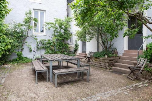 a picnic table and benches in front of a house at Nengshof Ferienhaus Königskerze in Wißmannsdorf