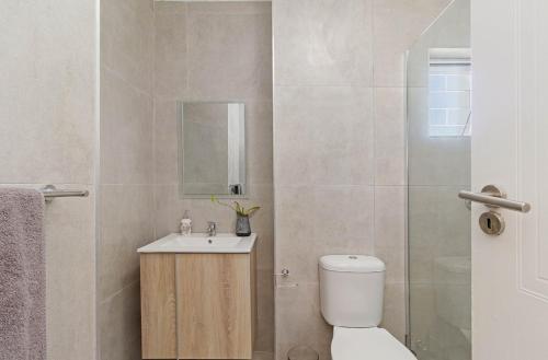 a bathroom with a toilet and a sink and a shower at The Sands Cottage in Cape Town