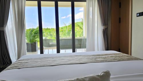 a bedroom with a bed and a large window at BB Luxury Villa in Phuket