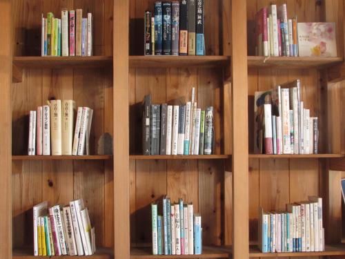 a book shelf filled with lots of books at 泊れる図書館 さんごさん in Goto