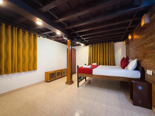 a bedroom with a bed in a room at Keloth Tharavadu in Panamaram