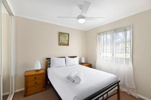 a bedroom with a bed with two white towels on it at Fravent house in Toukley