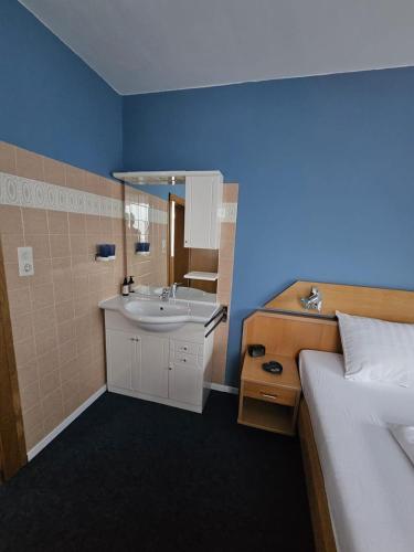 a bathroom with a sink and a bed in a room at Mirnockblick Apartments 2 in Radenthein