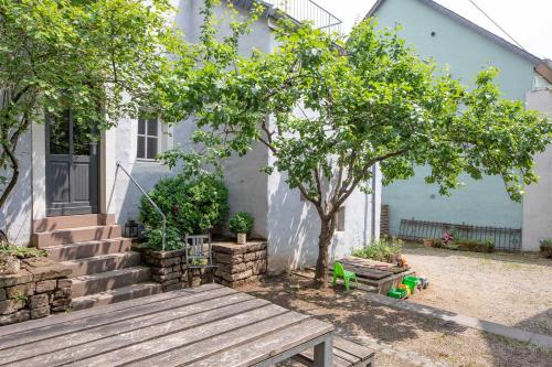 a house with a wooden bench and a tree at Nengshof Ferienhaus Ehrenpreis in Wißmannsdorf