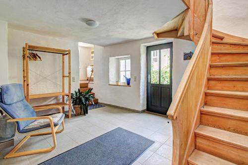 a living room with a staircase and a blue chair at Nengshof Ferienhaus Ehrenpreis in Wißmannsdorf