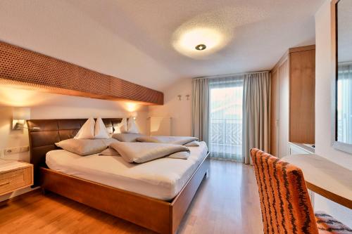 a bedroom with a large bed and a window at Pension Regina in Lech am Arlberg