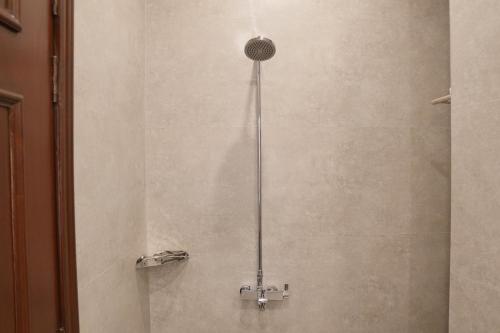 a shower with a shower head in a bathroom at RT Serene Hotel - Larkana in Lāhori