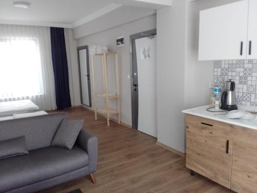 a living room with a couch and a kitchen at ROSe OTEL in Ezine