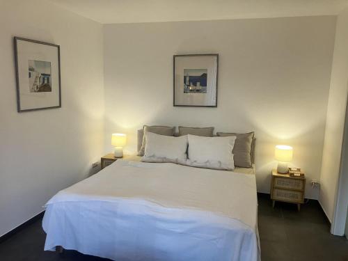 a bedroom with a large white bed with two lamps at Ferienwohnung Rolofs in Bad Nenndorf