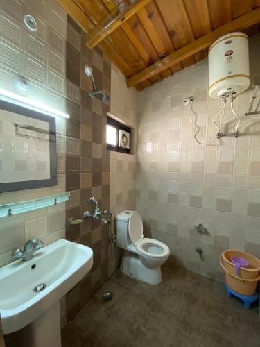 a bathroom with a toilet and a sink at Hotel Panorama Lake View in Nainital