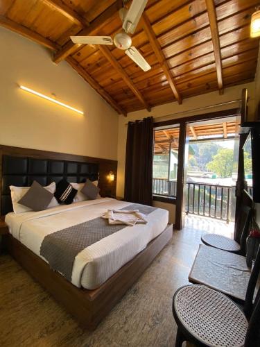 a bedroom with a large bed and a balcony at Hotel Panorama Lake View in Nainital