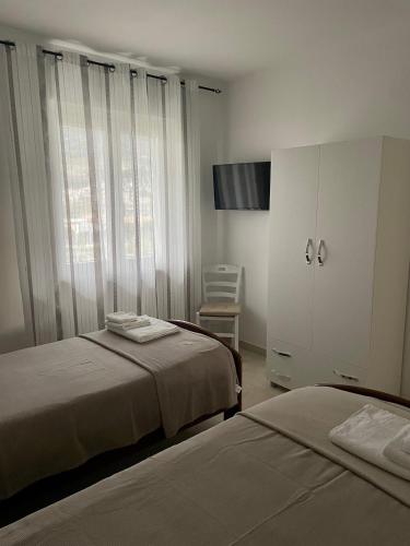 a bedroom with two beds and a cabinet and a chair at TedHouse in Praia a Mare