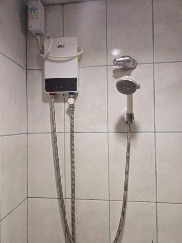 a bathroom with a hair dryer on a wall at Zhongkebole Suites in Baguio