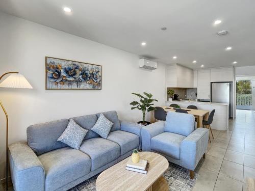 a living room with a couch and two chairs and a table at Bay View 2-Bedroom Apartment in Batemans Bay