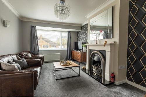 a living room with a couch and a fireplace at WOODFIELD ROAD - Two bed in Harrogate with cosy living room fire. in Harrogate
