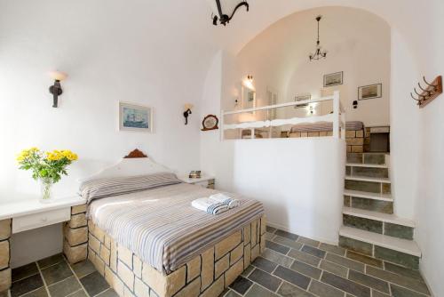 a bedroom with a bed and a staircase at Vallas Apartments & Villas in Firostefani
