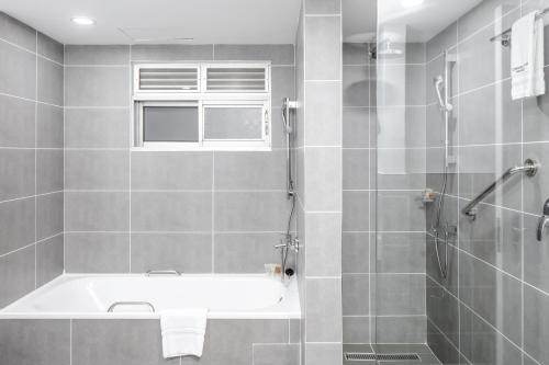 a bathroom with a bath tub and a shower at Constellation Apartments in Kampala
