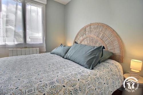 a bedroom with a large bed with a wooden headboard at Le palmier in Penvénan