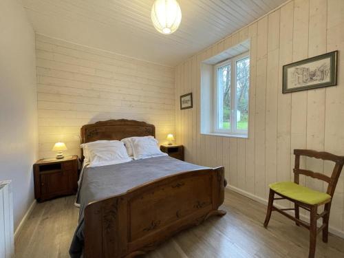 a bedroom with a bed and a chair and a window at Gite de l'isarce in Montaut