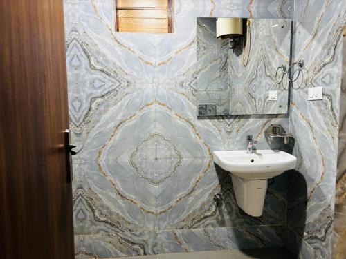 a bathroom with a sink and a toilet at JB Hotel and Resort in Lohaghāt