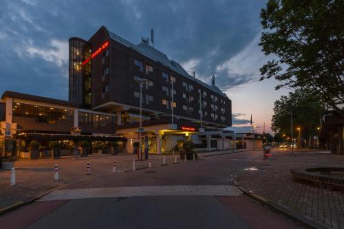 a large building on a city street at night at Leonardo Hotel Lelystad City Center in Lelystad