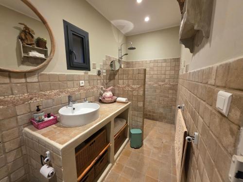 a bathroom with a sink and a mirror at Moulin AURELIA in La Barben