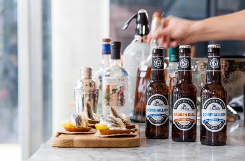 a counter with bottles of beer and a plate of food at Leman Locke in London