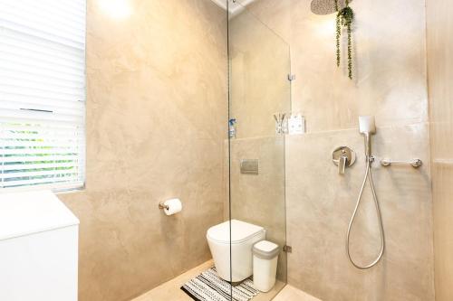 a bathroom with a shower with a toilet and a sink at Beach Bliss Pad in Ballito
