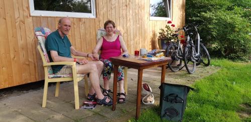 a man and a woman sitting at a table at Huisje de Bosrand in Bant
