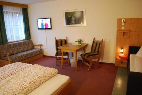 a bedroom with a bed and a table and chairs at Alpengasthof Götschenalm in Bischofswiesen