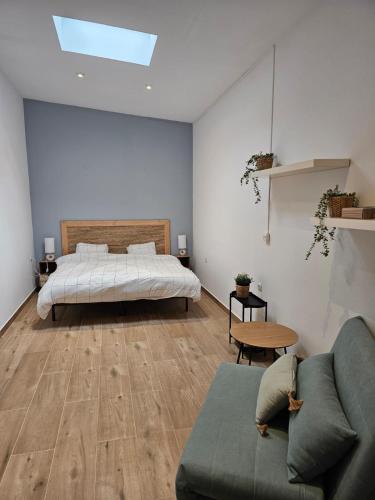 a bedroom with a bed and a couch and a bed at La Casa Delviga in Olivella