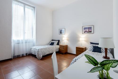 ミラノにあるVittoria Arconatiのベッドルーム1室(ベッド2台、ランプ付きテーブル付)