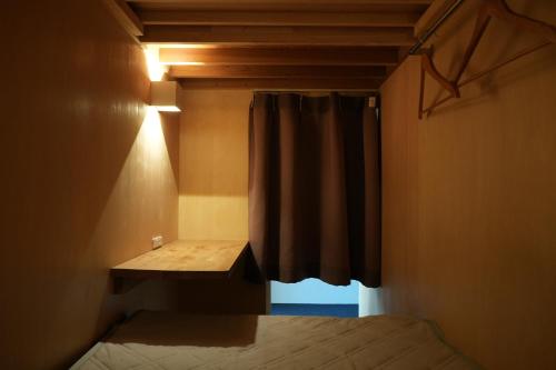 a small bedroom with a bed and a window at Santiago Guesthouse Kyoto in Kyoto