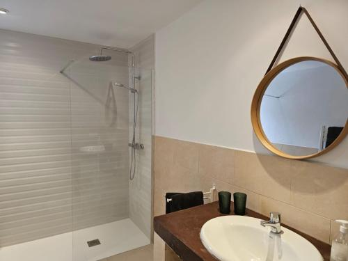 a bathroom with a sink and a shower with a mirror at La Casa Delviga in Olivella