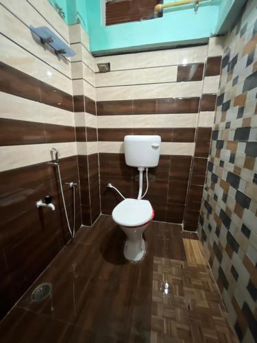 a small bathroom with a toilet and a shower at Jaykishan sadan in Varanasi