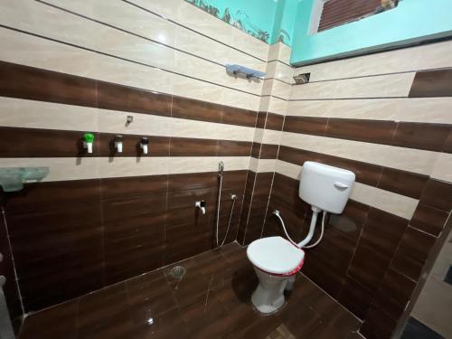 a bathroom with a toilet and wooden walls at Jaykishan sadan in Varanasi