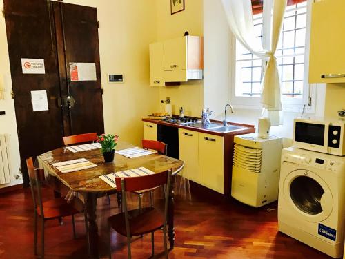 eine Küche mit einem Tisch und einer Waschmaschine in der Unterkunft TL Palazzo Fantuzzi in Bologna