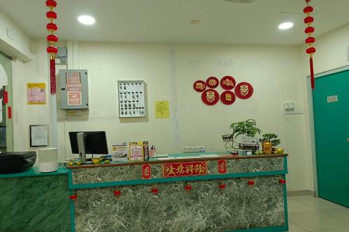 a lobby with a counter with red decorations on the wall at Sun Tree Hotel at Triang in Kampong Kerayong