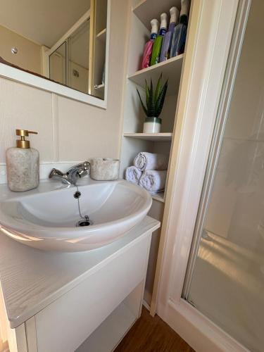 a bathroom with a sink and a mirror and towels at Static home sleeps 6 in Dawlish Warren