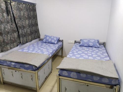 two twin beds in a room at Sainik Dormitory and Room Service in Lucknow