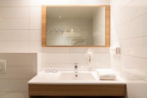 a bathroom with a sink and a mirror at The Originals Residence Appart Hôtel Hévéa Valence in Valence