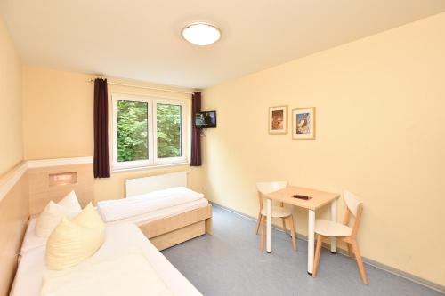 a hotel room with a bed and a table at Villa Ephraim in Görlitz