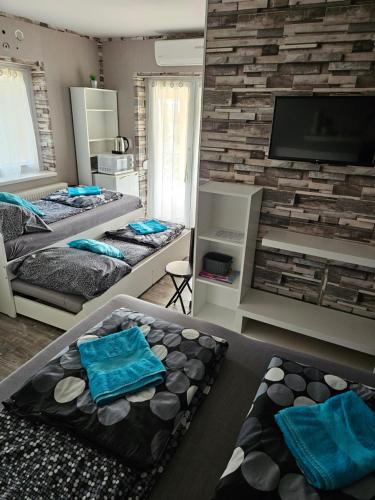 a bedroom with two beds and a flat screen tv at Kids' Paradise House in Balatonboglár