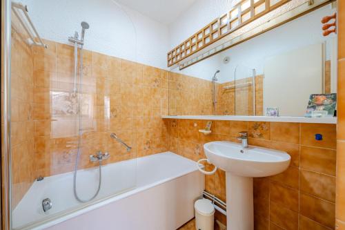 a bathroom with a tub and a sink and a shower at Résidence "Le Golfe Bleu" in Roquebrune-Cap-Martin