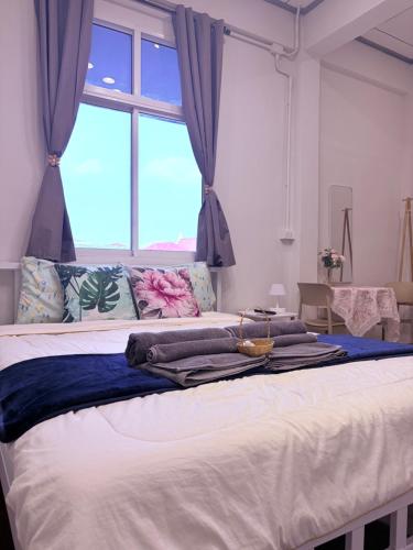 a bedroom with a large bed with a window at Pion Hotel Ayutthaya in Phra Nakhon Si Ayutthaya