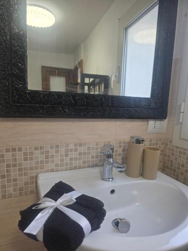 a bathroom sink with a black and white towel on it at Appartamento Dancardi in Quartu SantʼElena