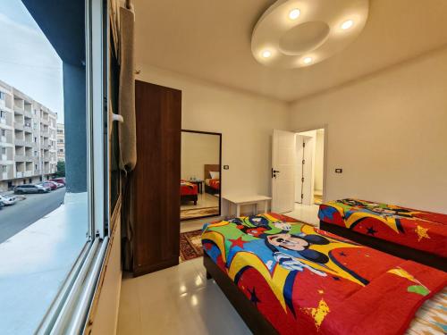 a bedroom with a bed and a large window at Red Sea Downtown in Hurghada