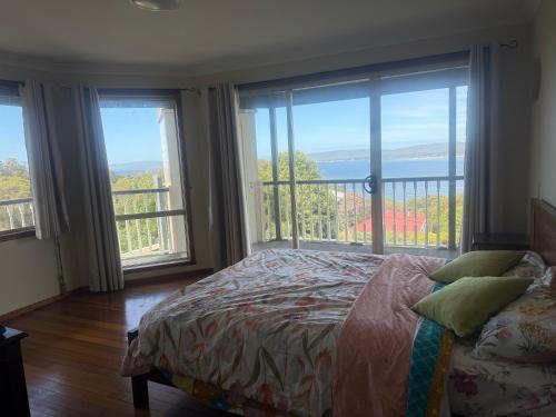 a bedroom with a bed and large windows at Pillais B and B in Albany