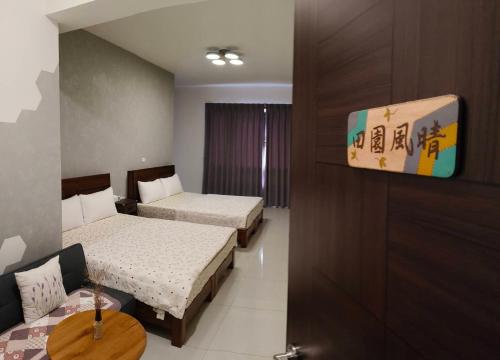 a hotel room with two beds and a tv at 稼鄉旅宿 in Xizhou