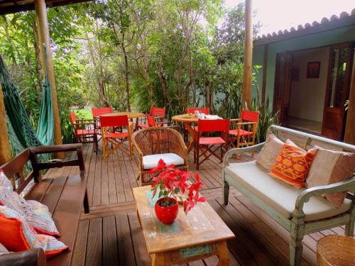 a wooden deck with a table and chairs on it at Casa Morada dos Pássaros - 3 suítes in Imbassai